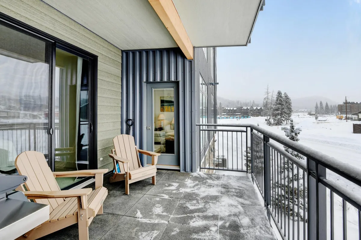 A private balcony with Adirondack chairs and a balcony railing, overlooking a snowy, serene landscape. The setting is tranquil, perfect for sipping hot drinks, reading, or simply taking in the view.